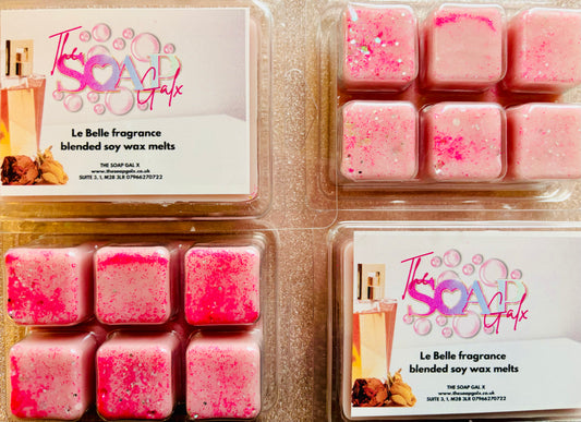 Two packages of Le Bella Perfume Inspired Soy Wax Melts with sprinkles on a wooden surface by The Soap Gal x.