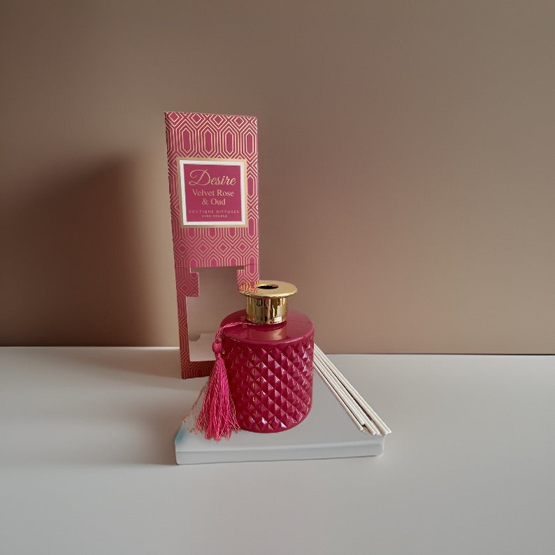 A pink Velvet Rose And Oud reed diffuser bottle with a velvet rose tassel on top by The Soap Gal x.