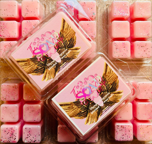 Two Olympea Perfume Inspired Soy Wax Melt containers with a bird design, surrounded by pink scented wax cubes by The Soap Gal x.