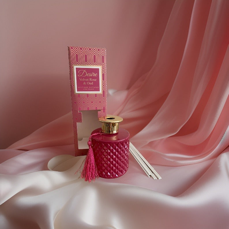 A pink Velvet Rose And Oud reed diffuser bottle with a velvet rose tassel on it from The Soap Gal x.
