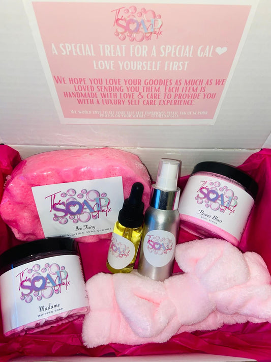 A pink Mystery Box with a variety of skincare products in it from The Soap Gal x.