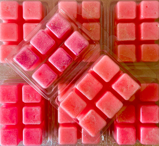 Several packs of highly scented Frosted Rose Wonderland Wax Melts from The Soap Gals are displayed, each containing six individual square-shaped melts in plastic containers, arranged in a layered pattern.