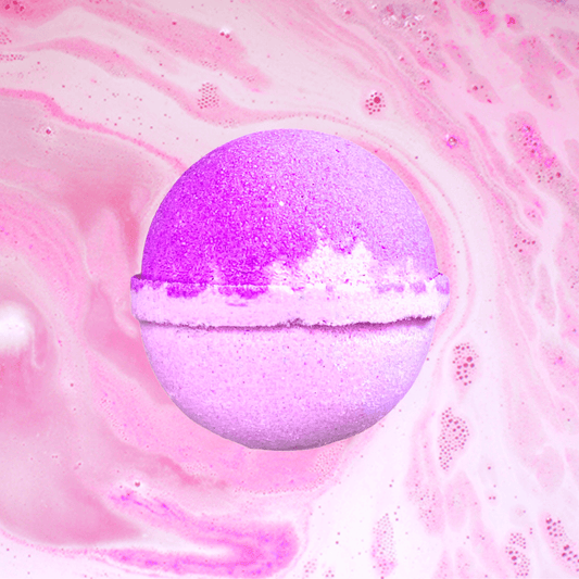 A purple The Soap Gals Olympia Bath Bomb dissolving in water with fizzy bubbles and pink swirls.