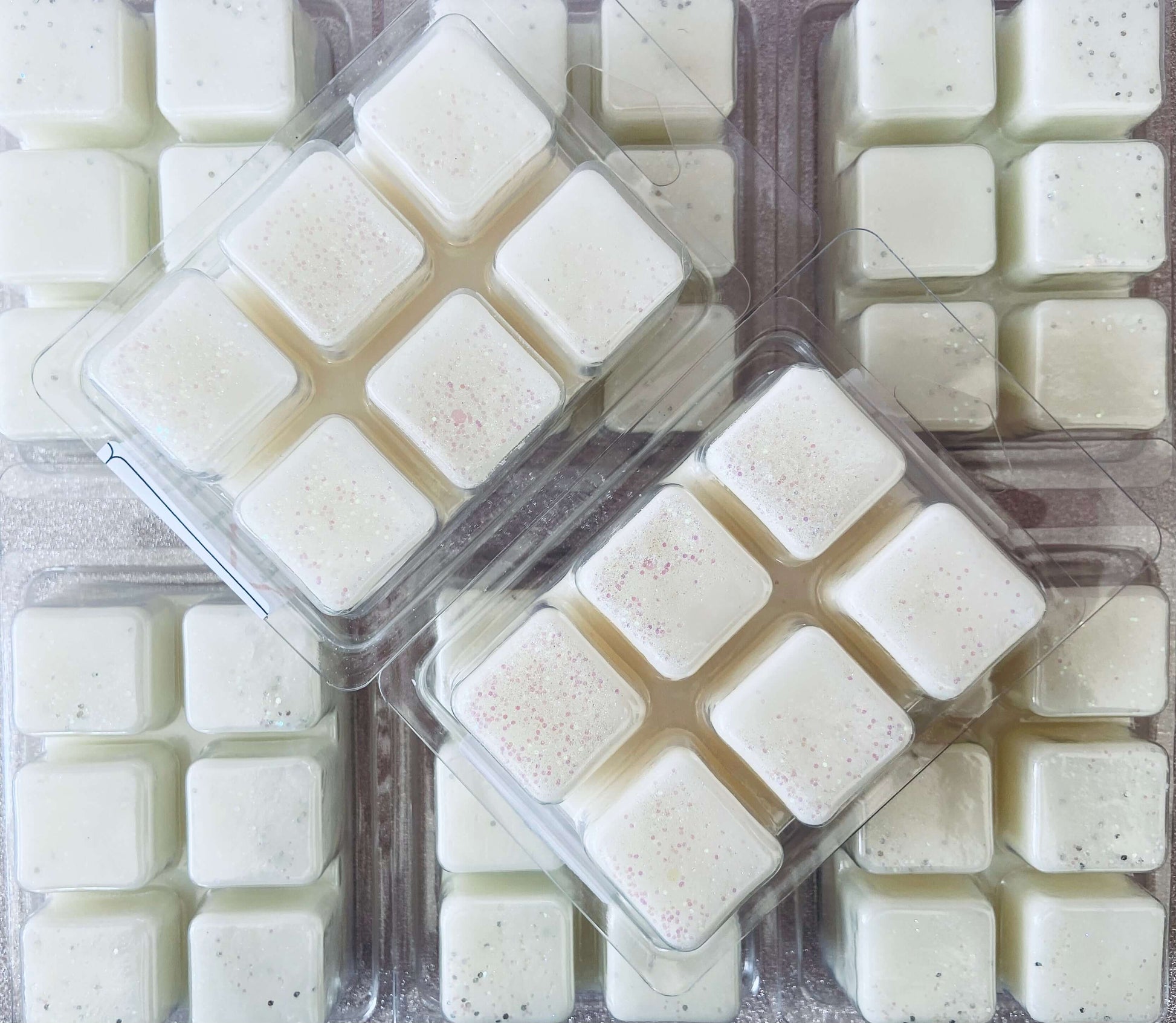 A group of Fresh Linen wax melts from The Soap Gals infused with fragrance oils on a table.