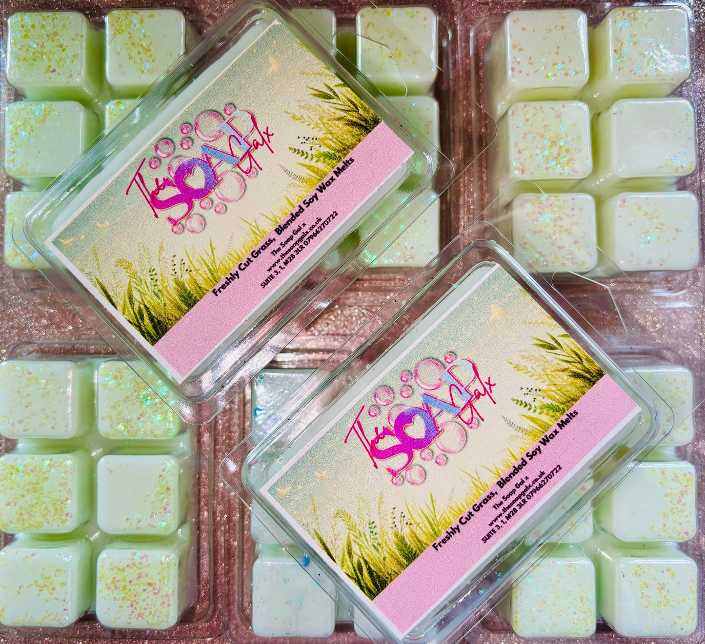 Packaged Fresh Cut Grass Wax Melts by The Soap Gal x arranged next to an open container displaying the product.