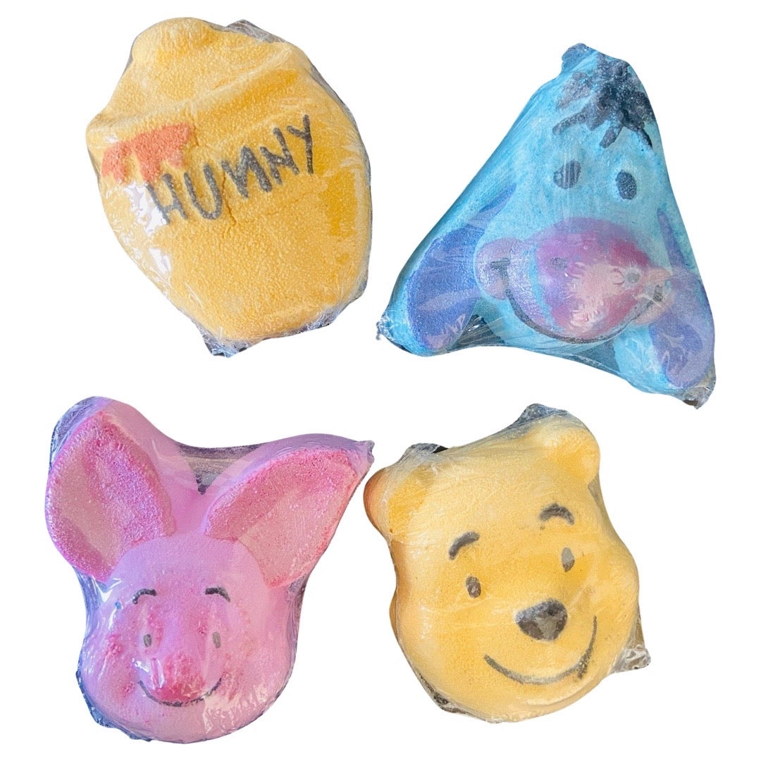 Four Winnie and Friends Bath Bombs, evocative of childhood memories, are shaped like characters and elements from Winnie The Pooh by The Soap Gal x.