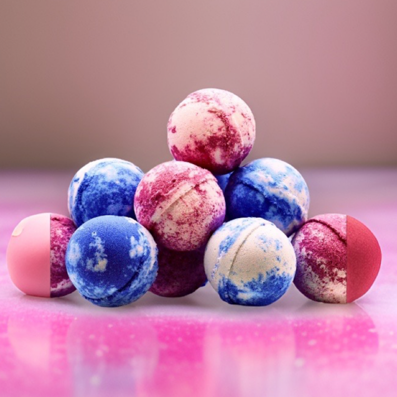 A close-up of a luxurious pile of Random Scented Jumbo Bath Bombs in shades of pink and blue, displayed on a reflective surface by The Soap Gal.