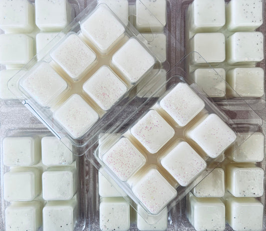 Trays of square-shaped, assorted soy wax melts with different textures and speckles, including The Soap Gal x Vanilla & Oud Wax Melt.