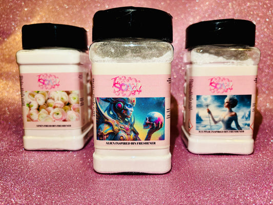Three jars of Bin Buddi Bin Freshener powder on a pink background by The Soap Gals.