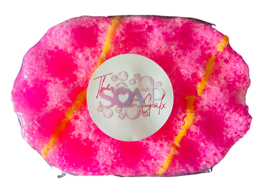 A pink Mini Exfoliating Soap Sponge with yellow and pink sprinkles on it from The Soap Gal x.