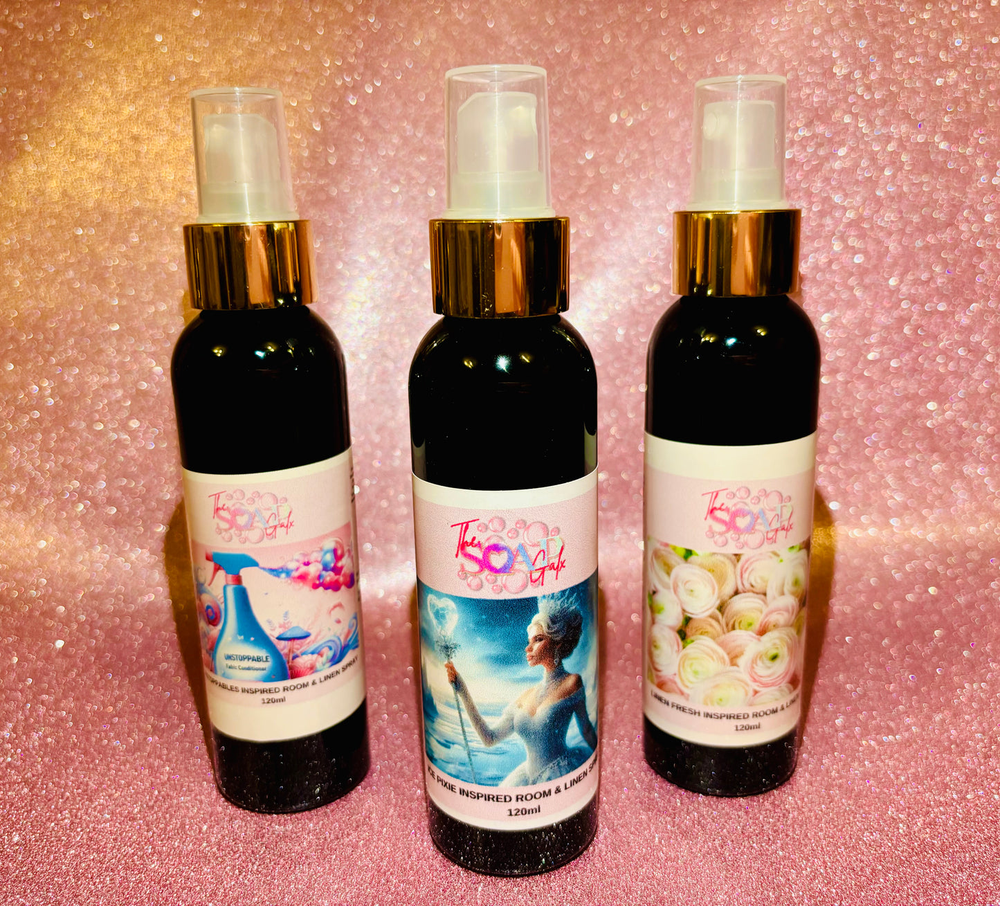 Three Inspired Room Sprays by The Soap Gals with different scents on a glittery pink background.