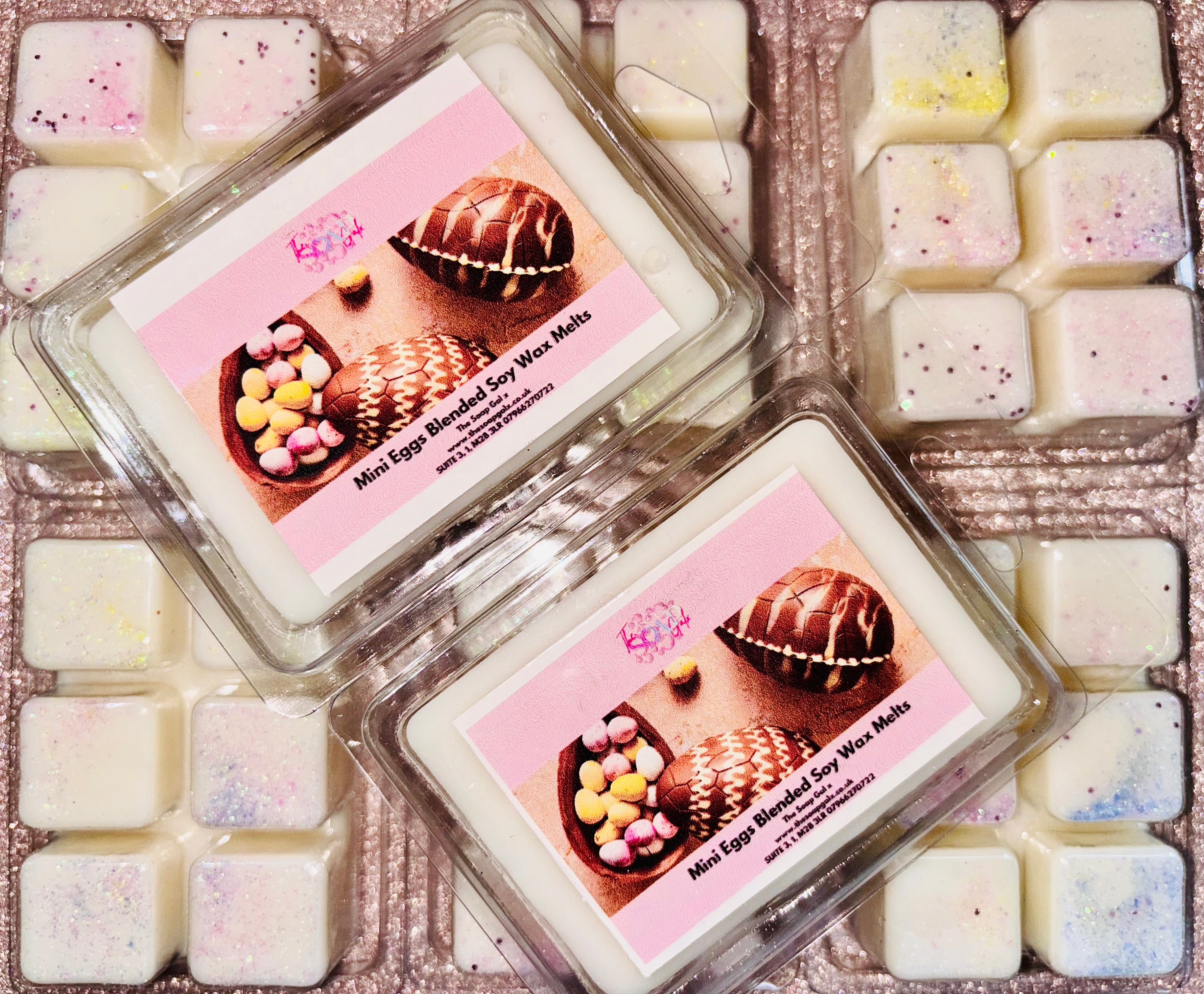 A box of Chocolate Egg Easter scented wax melts from The Soap Gal x on top of a pink plate.