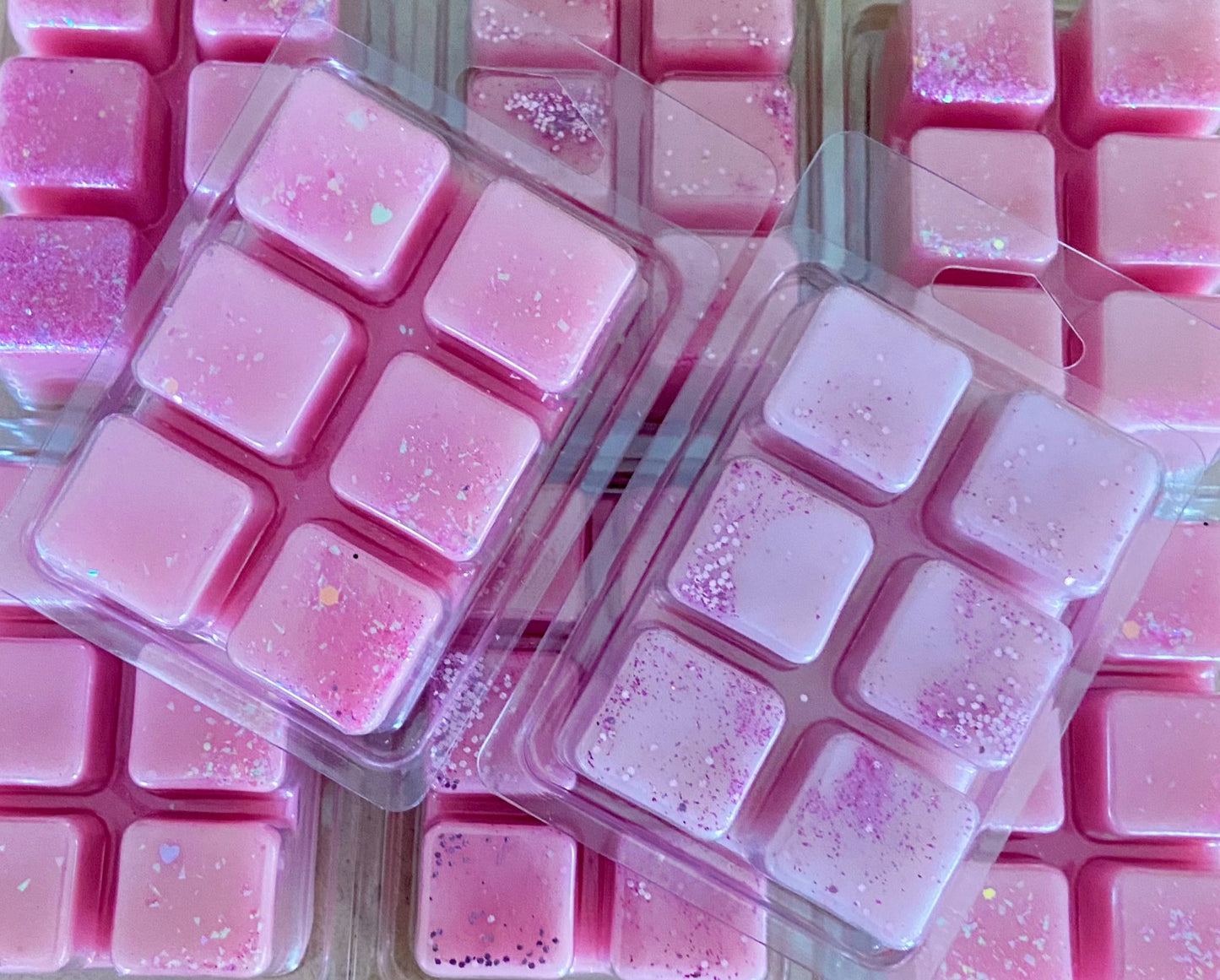 Tray of The Soap Gal x Castle of Dreams Wax Melt sprinkled with glitter, displayed in clear plastic packaging on a pink background.