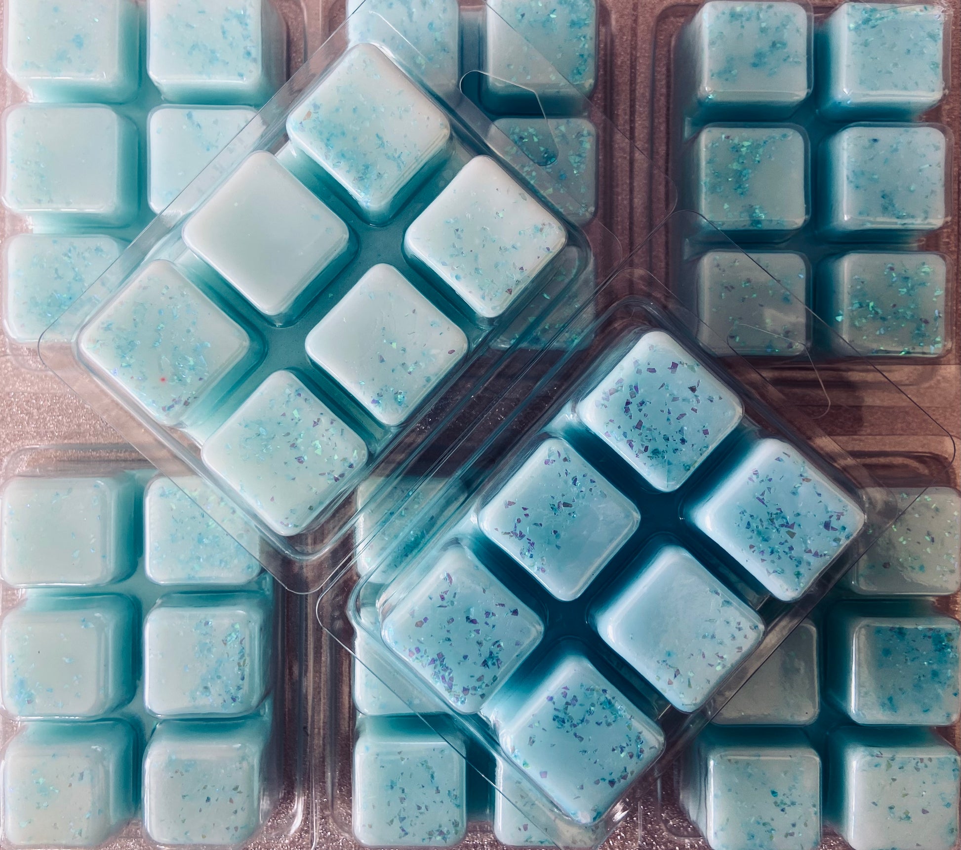 Packaged Sauvage Aftershave Inspired wax melts in various shades of blue with speckled details by The Soap Gals.