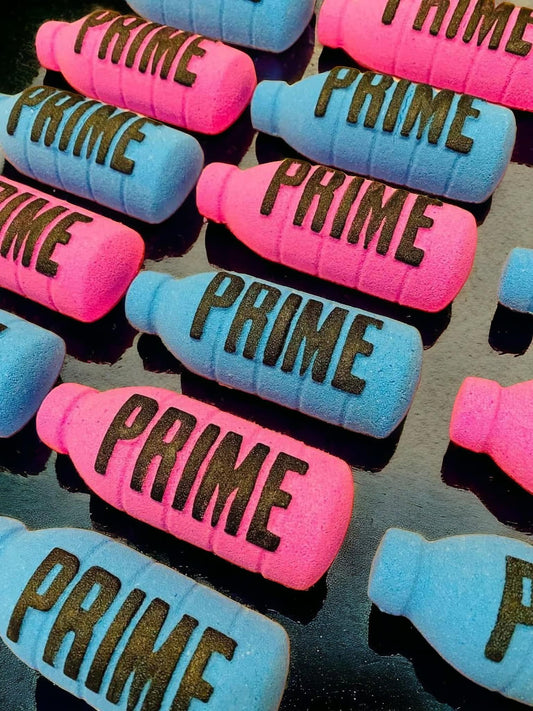 Colorful capsules with the word "Pink Prime Bottle Marshmallow Bath Bomb" printed on them, featuring a marshmallow scent by The Soap Gal x.