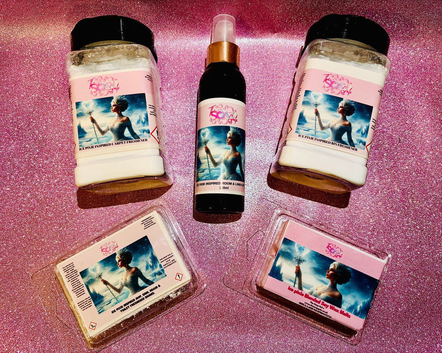 A collection of The Soap Gals' home fragrance products with matching labels on a sparkly pink background.