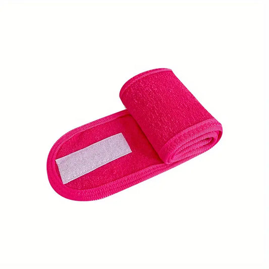 A rolled-up pink Spa Facial Super Soft Make Up Velcro Closure Stretch Towel headband by The Soap Gal, isolated on a white background.