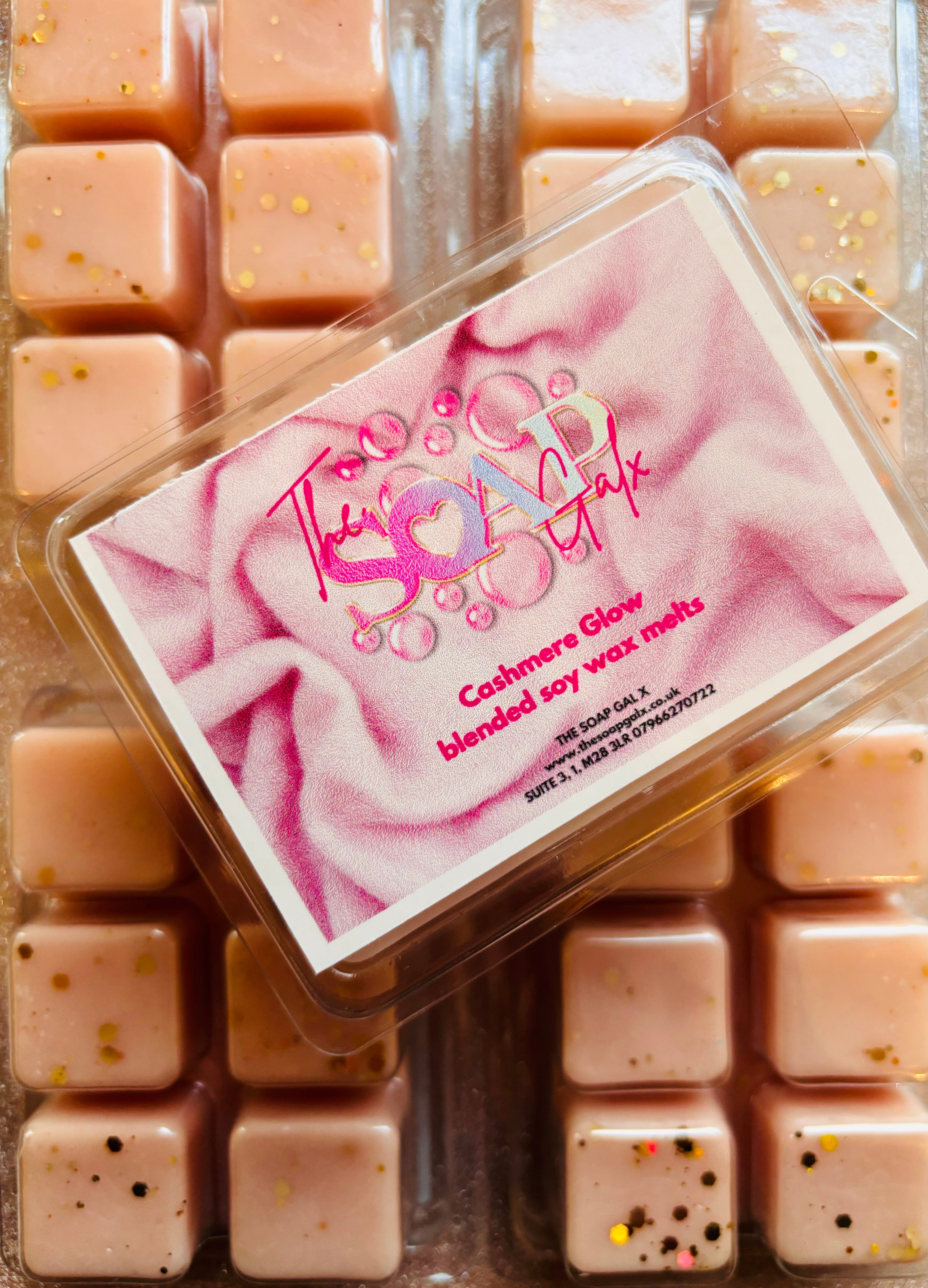 A box of pink Cashmere Glow scented soy wax cubes (Cashmere Glow Soy Wax Melts by The Soap Gal) sitting on top of each other.