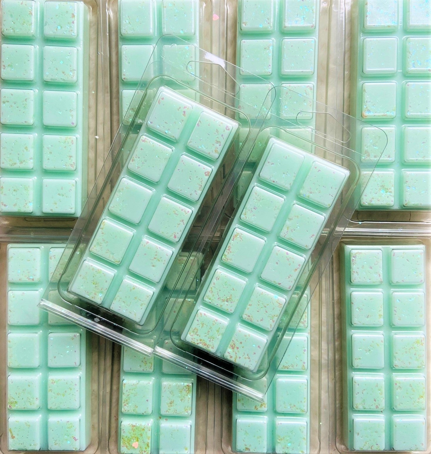 Packaged mint-green Lime Mojito Wax Melts from The Soap Gal x sprinkled with biodegradable glitter arranged in rows.