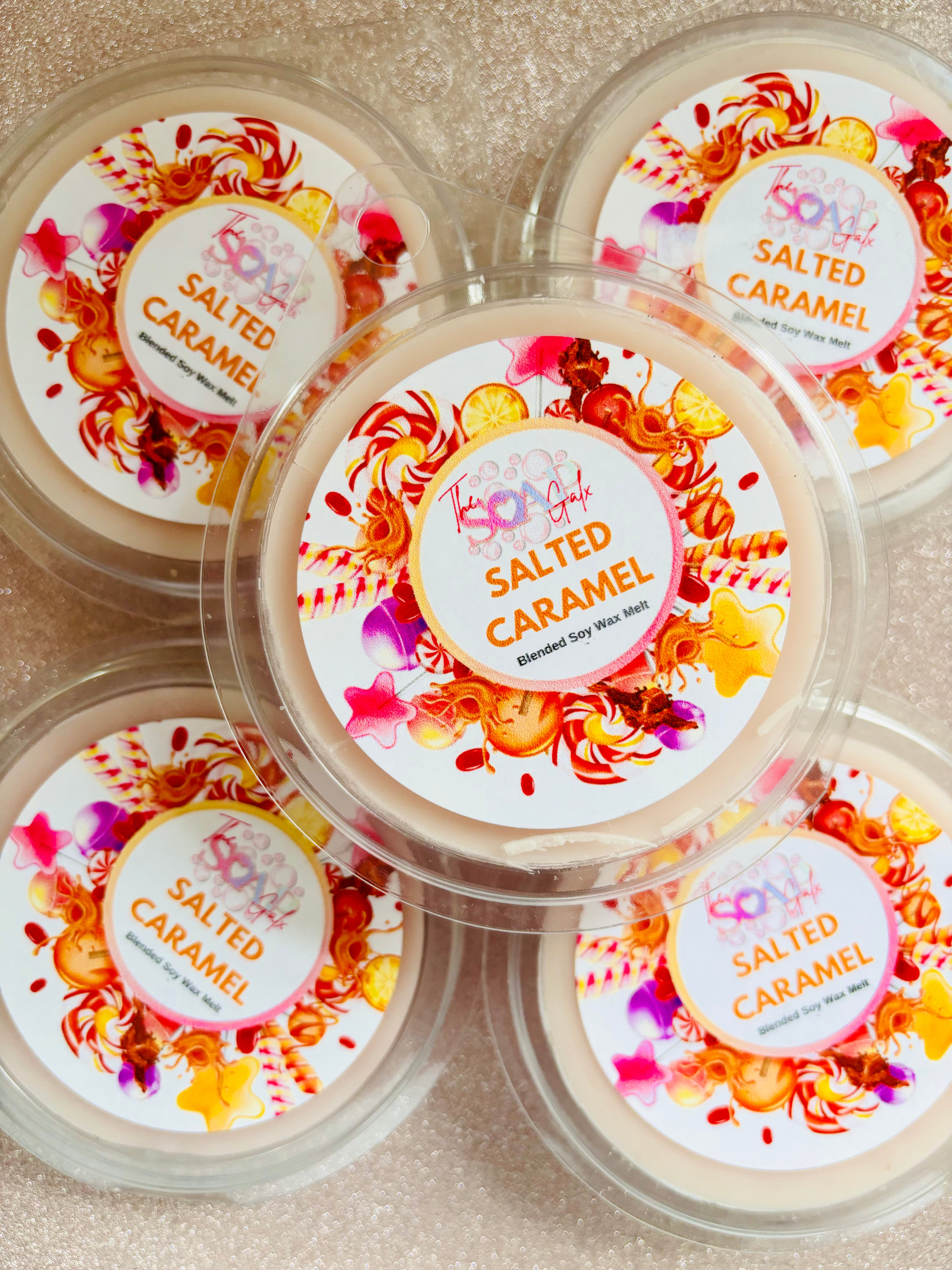 Stack of Salted Caramel Wax Melt containers with colorful labels in clamshell packaging by The Soap Gal x.