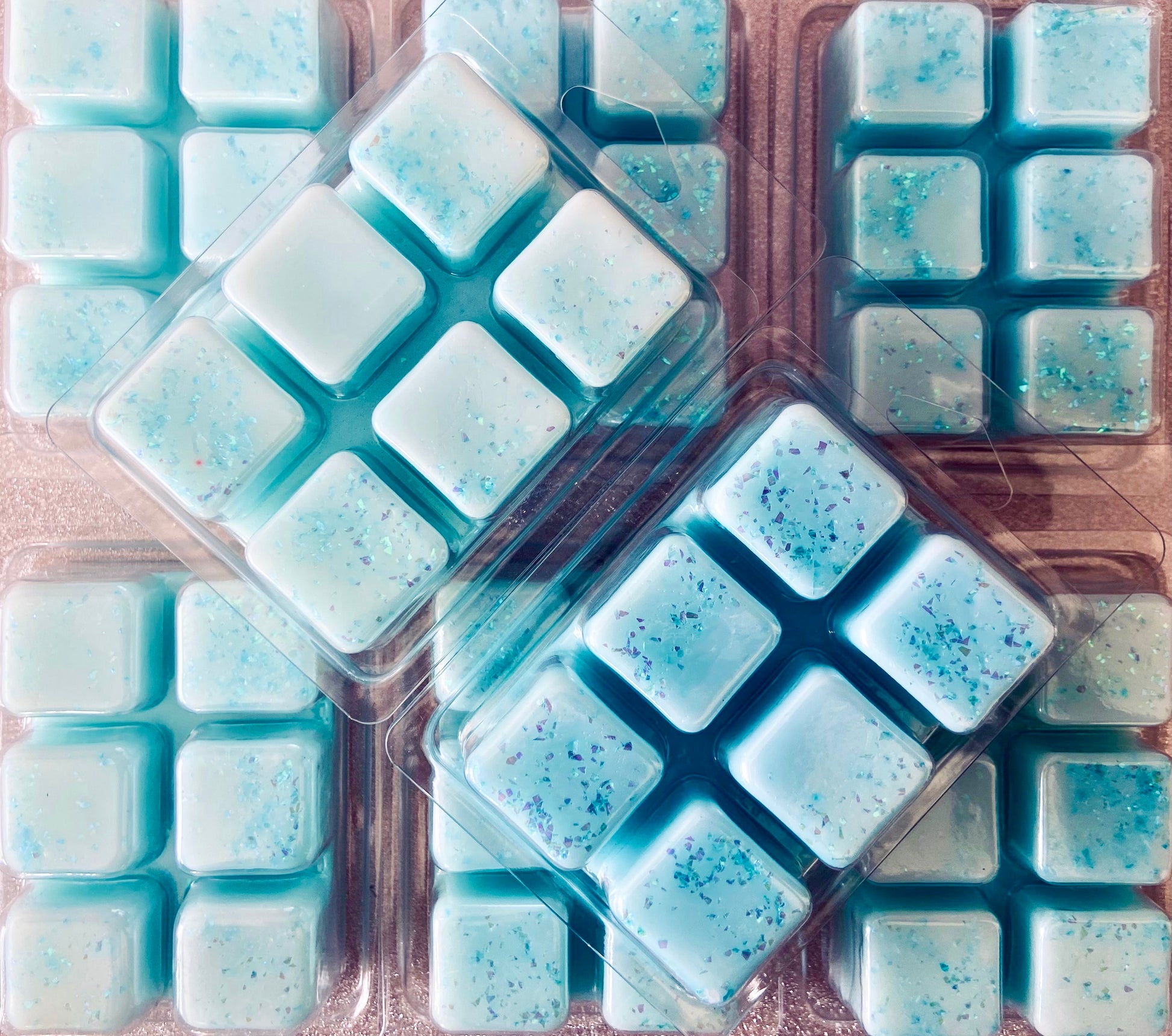 Assorted blue Invictus soy wax melts in clear plastic packaging by The Soap Gals.