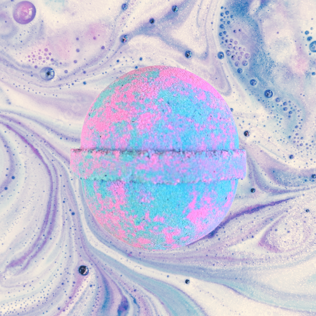 A Baby Powder Bath Bomb from The Soap Gals dissolving in water, creating a swirling pattern of pastel hues.