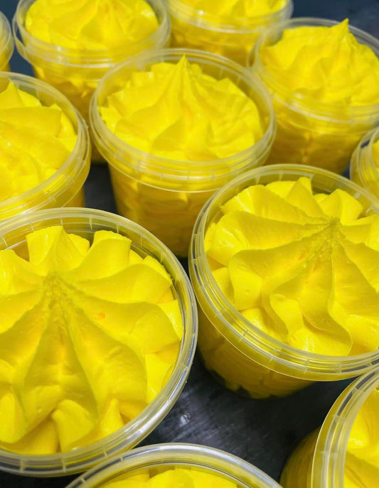 Bright yellow Citronella Whipped Soap 100ml piped in a star pattern atop cakes, each in a clear plastic container from The Soap Gal x.