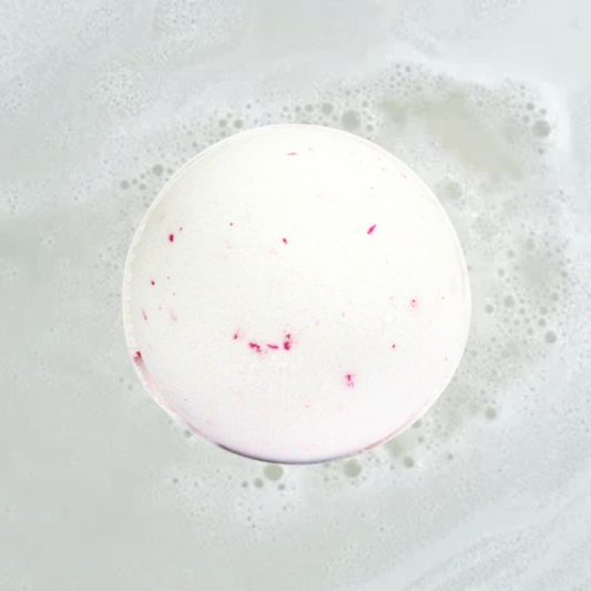 A The Soap Gal x Coconut Dream Jumbo Bath Bomb dissolving in water with effervescent bubbles.