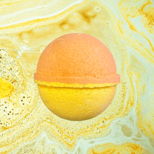 A round, two-toned Men’s Ceed Aventus Bath Bomb by The Soap Gals with orange and yellow colors, floating in a bath with swirling orange and yellow water.