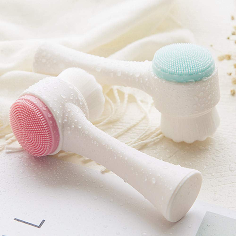 Two Exfoliating Face Brushes from The Soap Gal x with soft bristles, one with a pink and the other with a turquoise head, covered in water droplets on a towel.