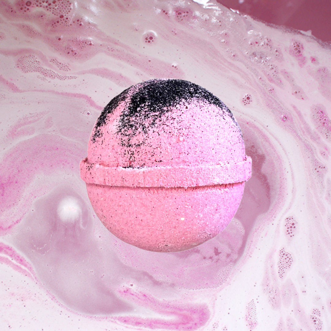 Pink Opium Bath Bomb from The Soap Gals dissolving in water with frothy swirls.