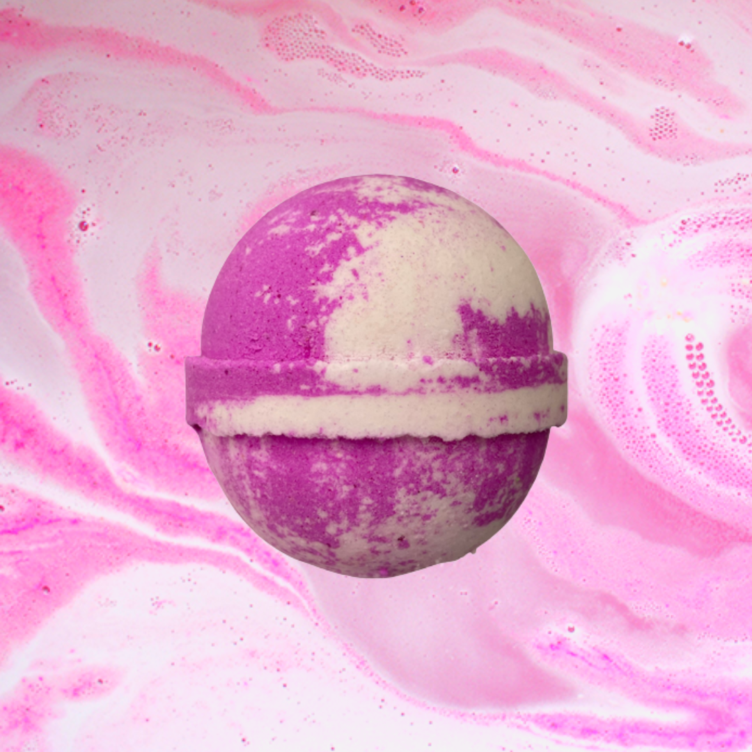 A Pink Sugar Cocktail Bath Bomb by The Soap Gals floats elegantly on a pink and white marbled background.