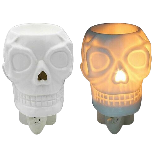 Two identical skull-shaped nightlights, one unlit in white and the other illuminated with a warm glow, resembling a White Skeleton Plug In Wax Warmer from The Soap Gal x, on a white background.