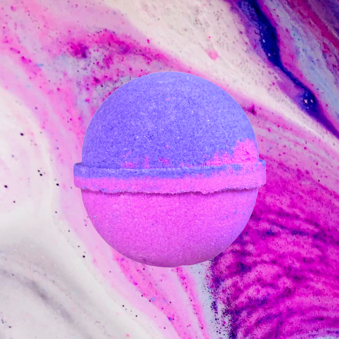 A luxury notes Women's Ceed Aventus bath bomb with a vibrant purple hue against a swirling pink and purple background by The Soap Gals.